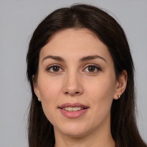 Joyful white young-adult female with long  brown hair and brown eyes