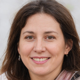 Joyful white adult female with long  brown hair and brown eyes