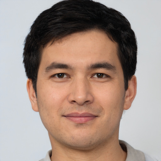 Joyful white young-adult male with short  black hair and brown eyes