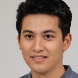 Joyful asian young-adult male with short  black hair and brown eyes