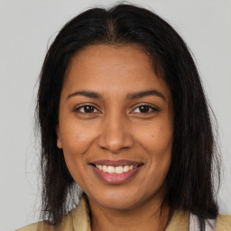 Joyful black young-adult female with long  brown hair and brown eyes