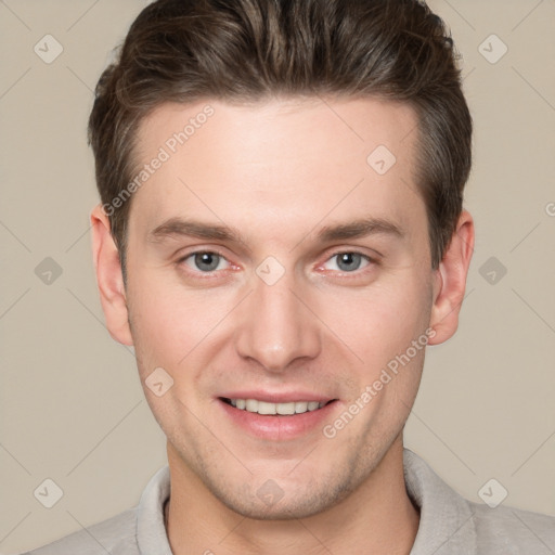 Joyful white young-adult male with short  brown hair and grey eyes