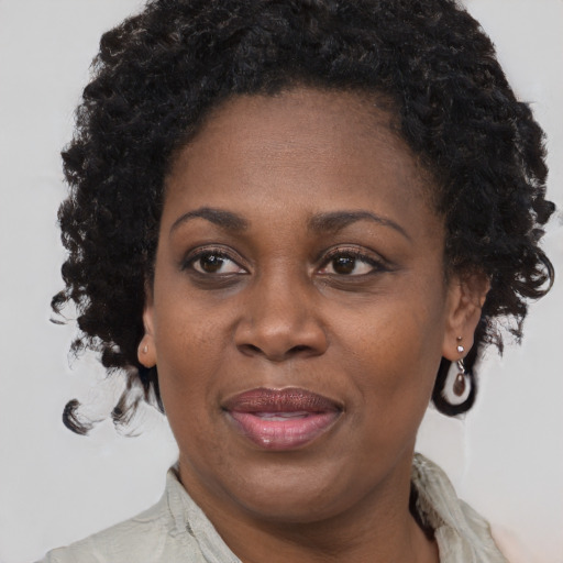 Joyful black adult female with long  brown hair and brown eyes