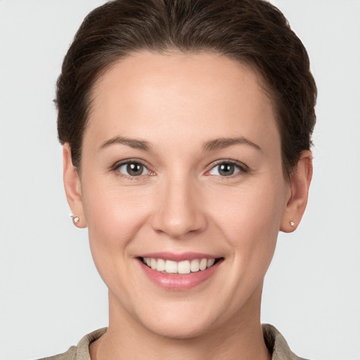 Joyful white young-adult female with short  brown hair and grey eyes