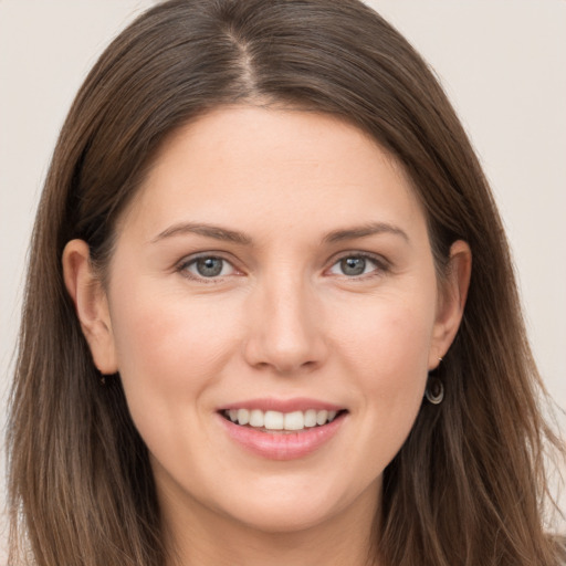 Joyful white young-adult female with long  brown hair and brown eyes