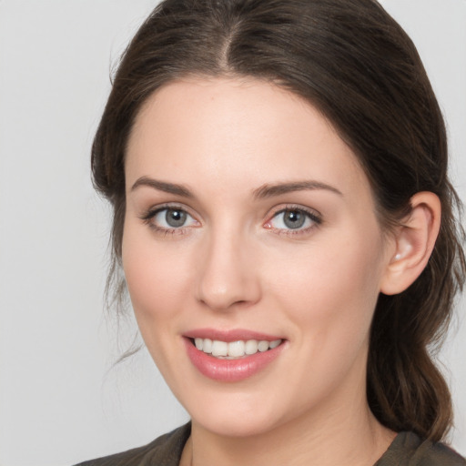 Joyful white young-adult female with medium  brown hair and grey eyes