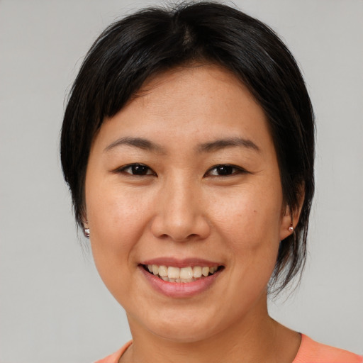 Joyful asian adult female with medium  brown hair and brown eyes