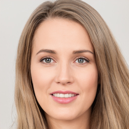 Joyful white young-adult female with long  brown hair and brown eyes