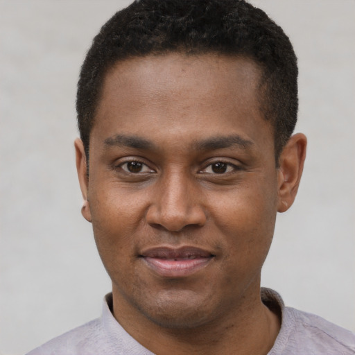Joyful black young-adult male with short  black hair and brown eyes