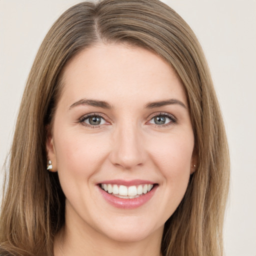 Joyful white young-adult female with long  brown hair and green eyes