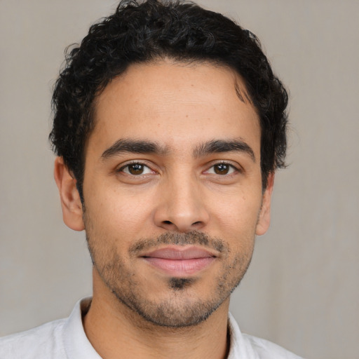 Joyful latino young-adult male with short  brown hair and brown eyes