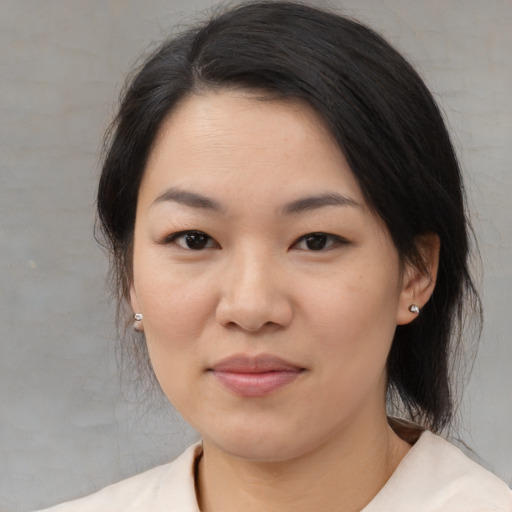 Joyful asian young-adult female with medium  black hair and brown eyes