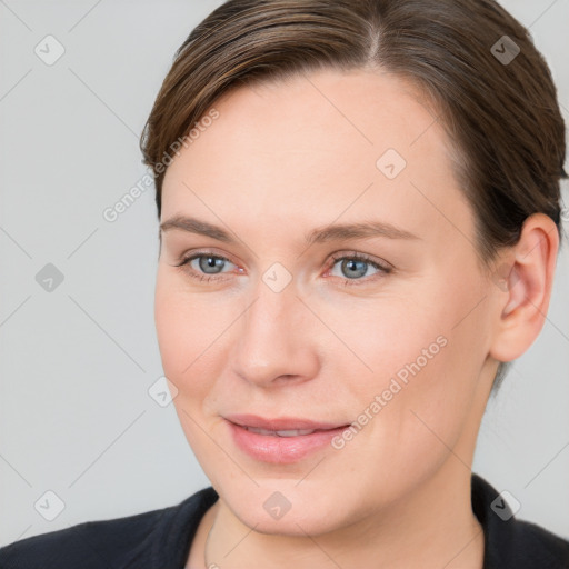 Joyful white young-adult female with short  brown hair and grey eyes