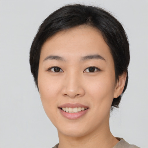 Joyful asian young-adult female with medium  black hair and brown eyes