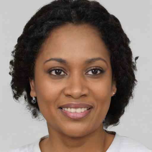 Joyful black young-adult female with medium  brown hair and brown eyes
