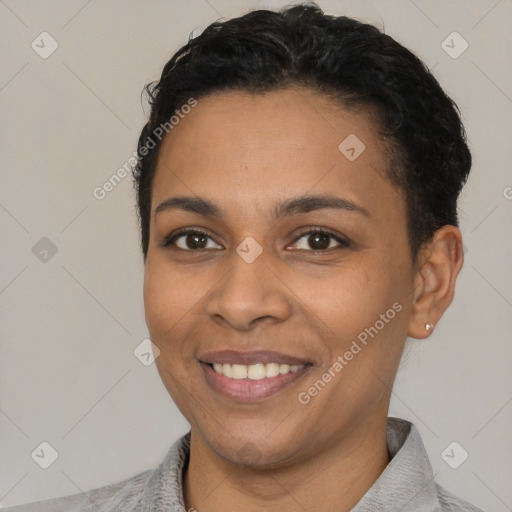 Joyful black young-adult female with short  black hair and brown eyes