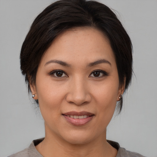 Joyful asian young-adult female with medium  brown hair and brown eyes