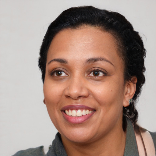 Joyful latino adult female with medium  black hair and brown eyes