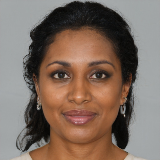Joyful black adult female with medium  brown hair and brown eyes