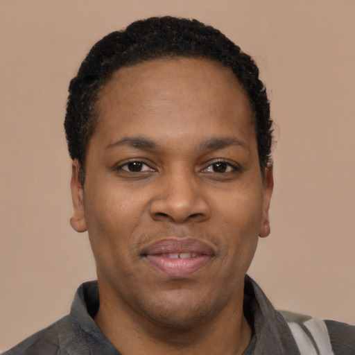 Joyful black young-adult male with short  black hair and brown eyes