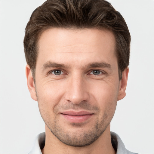 Joyful white young-adult male with short  brown hair and grey eyes