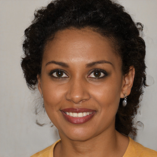 Joyful black young-adult female with medium  brown hair and brown eyes