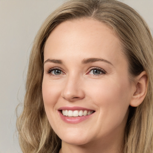 Joyful white young-adult female with long  brown hair and green eyes