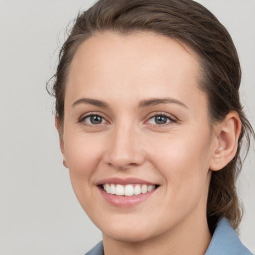 Joyful white young-adult female with medium  brown hair and grey eyes