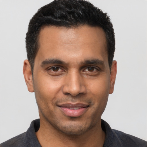 Joyful latino young-adult male with short  black hair and brown eyes