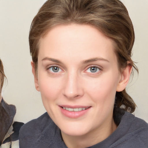 Joyful white young-adult female with medium  brown hair and blue eyes