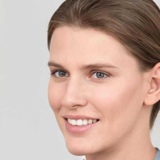 Joyful white young-adult female with short  brown hair and grey eyes