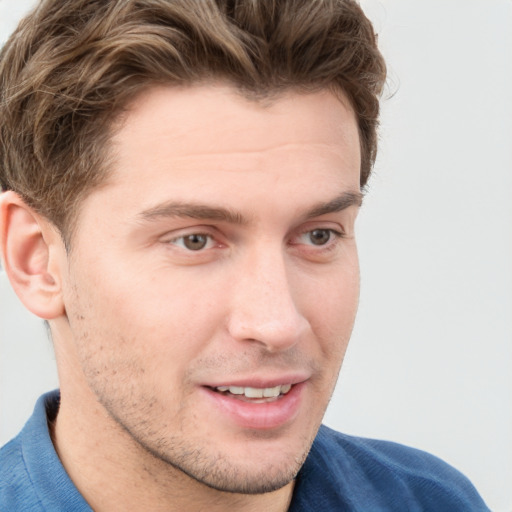 Joyful white young-adult male with short  brown hair and blue eyes