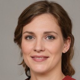 Joyful white young-adult female with medium  brown hair and grey eyes