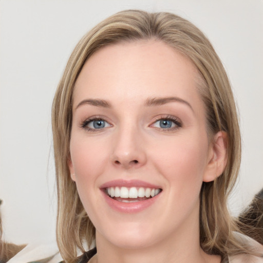 Joyful white young-adult female with long  brown hair and blue eyes