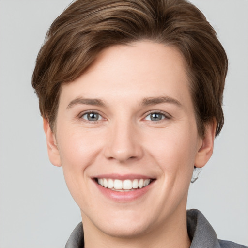 Joyful white young-adult female with short  brown hair and grey eyes