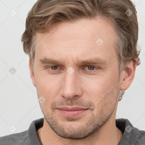 Joyful white adult male with short  brown hair and grey eyes