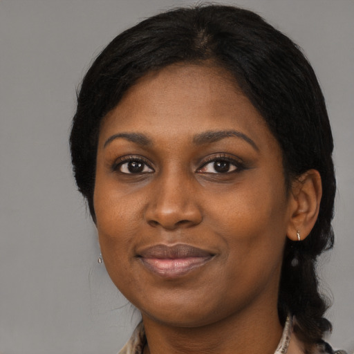 Joyful black young-adult female with long  black hair and brown eyes