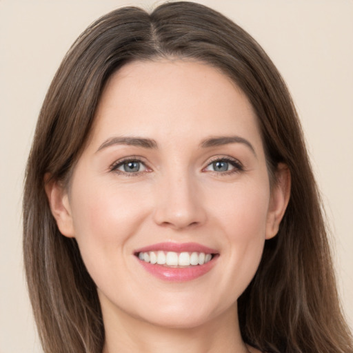 Joyful white young-adult female with long  brown hair and grey eyes