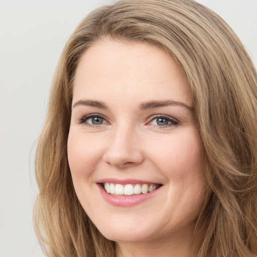 Joyful white young-adult female with long  brown hair and green eyes