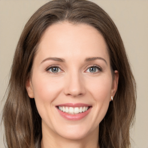 Joyful white young-adult female with long  brown hair and green eyes