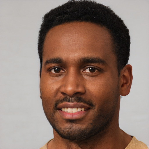 Joyful black young-adult male with short  black hair and brown eyes