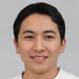 Joyful asian young-adult male with short  brown hair and brown eyes