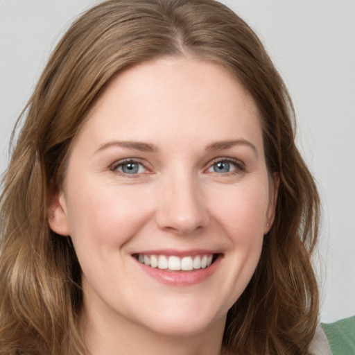 Joyful white young-adult female with long  brown hair and grey eyes