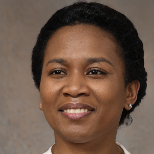 Joyful black young-adult female with short  black hair and brown eyes