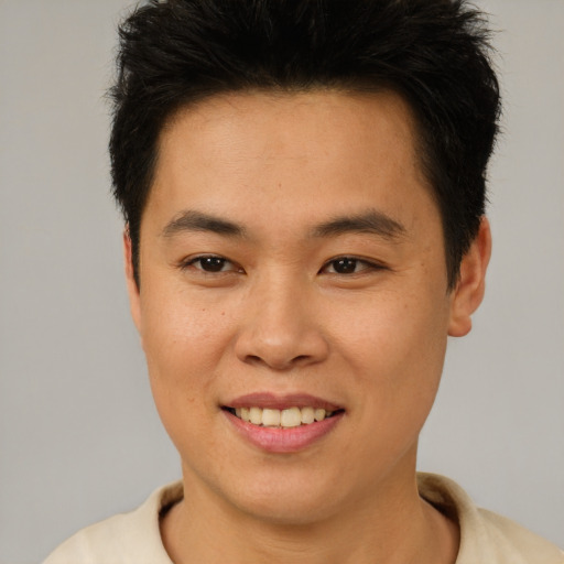 Joyful asian young-adult male with short  brown hair and brown eyes