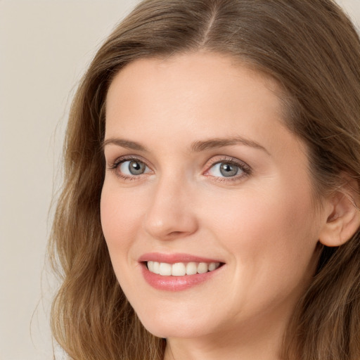 Joyful white young-adult female with long  brown hair and grey eyes