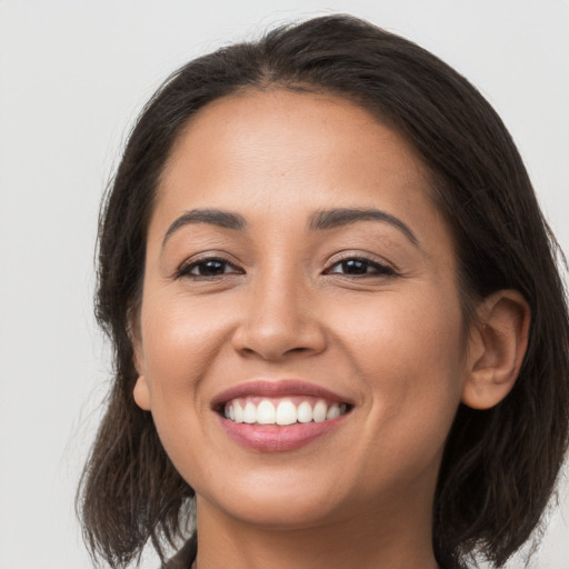 Joyful latino young-adult female with medium  brown hair and brown eyes