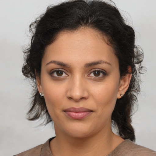 Joyful latino young-adult female with medium  brown hair and brown eyes