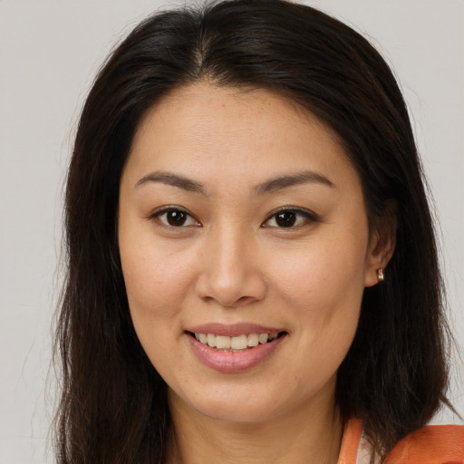 Joyful asian young-adult female with long  brown hair and brown eyes
