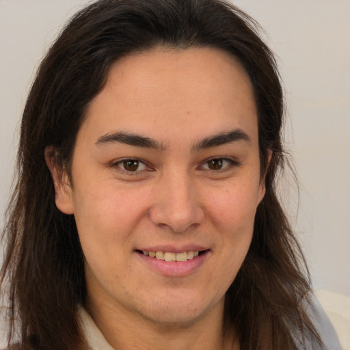 Joyful latino young-adult female with long  brown hair and brown eyes